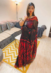 Black and red Dhakai Jamdani saree with intricate floral patterns and sheer fabric worn by a woman indoors.