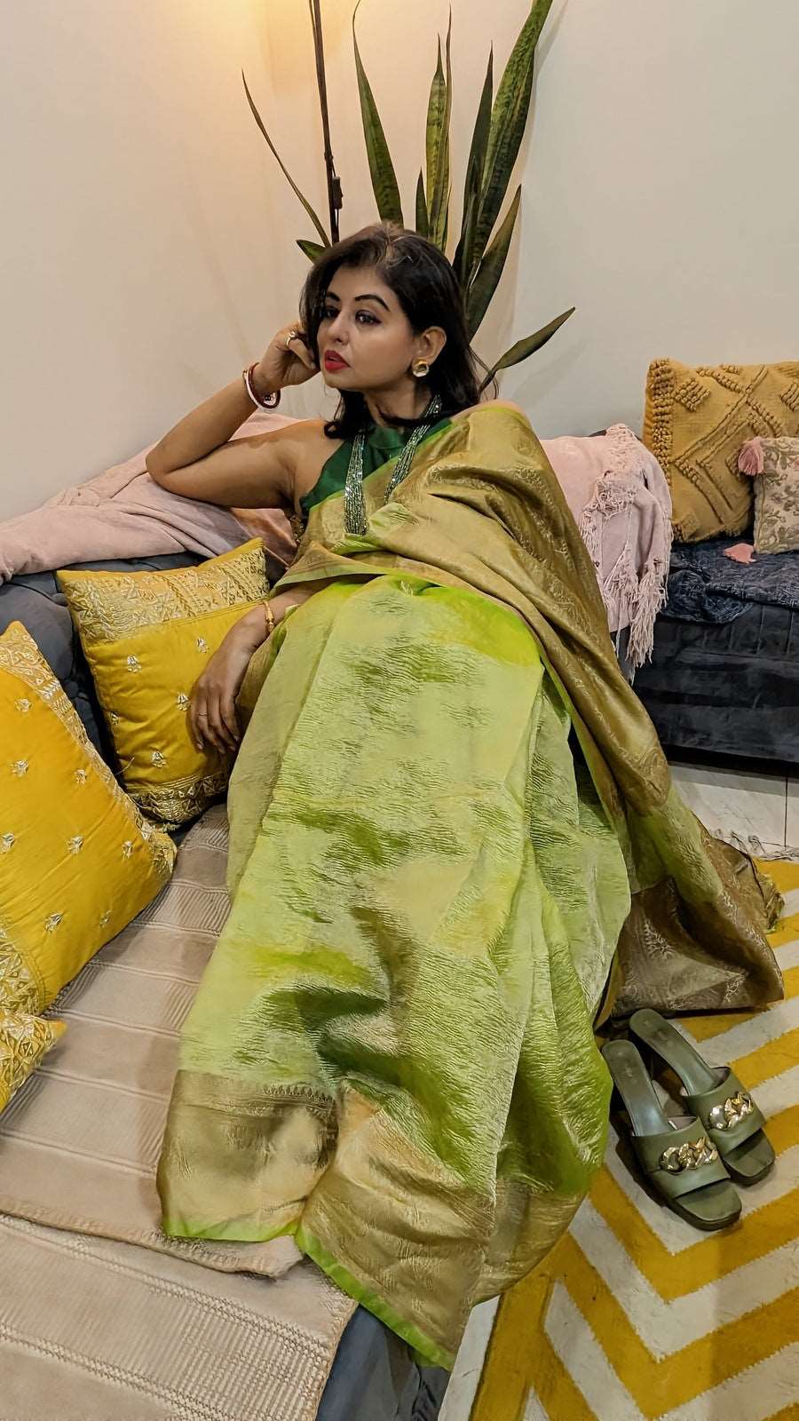 Leafy green crushed tissue Banarasi saree with subtle golden zari work worn with matching blouse.