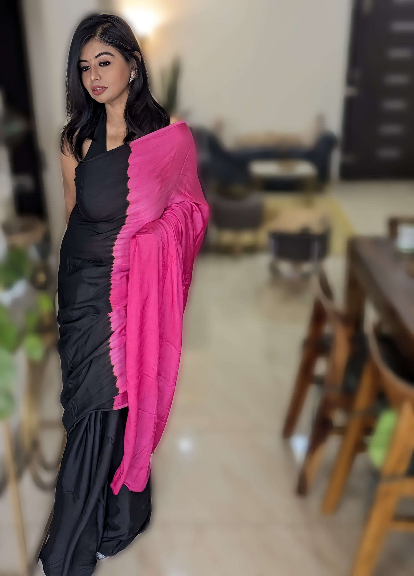 Black sleeveless blouse paired with elegant black and magenta tie-dye viscose modal silk saree with ruffled magenta pallu.