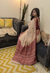 Cream Bengal cotton saree with red floral border and small red motifs, worn with matching red blouse.
