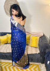 Royal blue silk Paithani saree with silver border and gold motifs, worn with matching blouse.