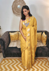 Golden yellow Banarasi silk saree with intricate floral patterns and delicate zari border.
