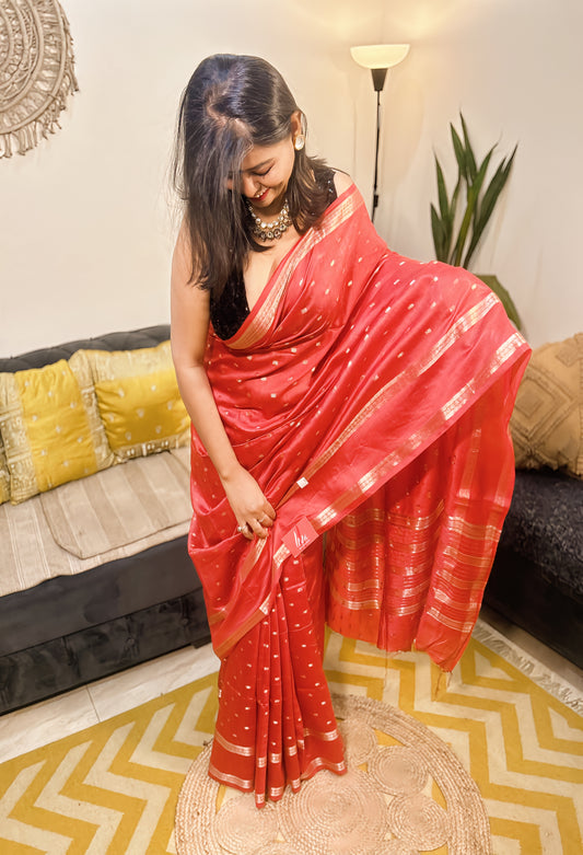 Red cotton silk Maheshwari saree with gold motifs and border, styled with black blouse.