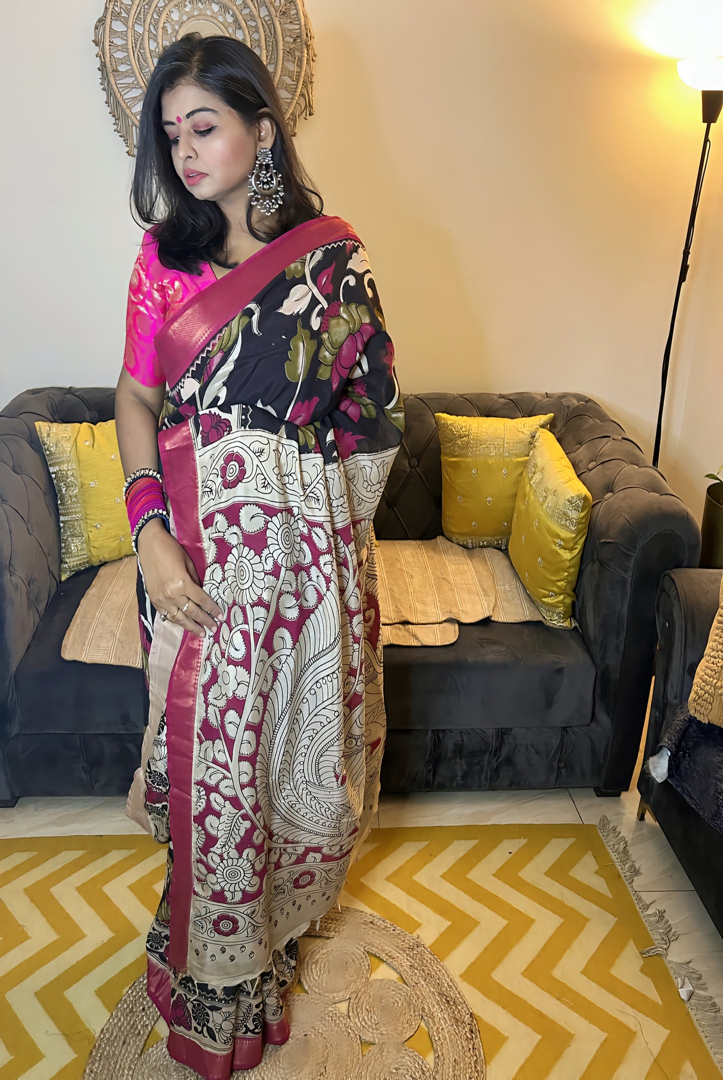 Black and ivory silk Kalamkari saree with pink blouse, intricate floral patterns, and gold border detailing.