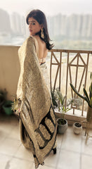 Black Khaddi chiffon georgette Banarasi saree with gold zari border draped on model with open back blouse.
