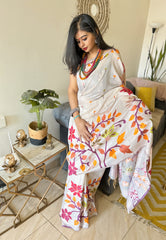 Ivory silk Jamdani saree with colorful floral motifs worn with red and orange layered necklace.