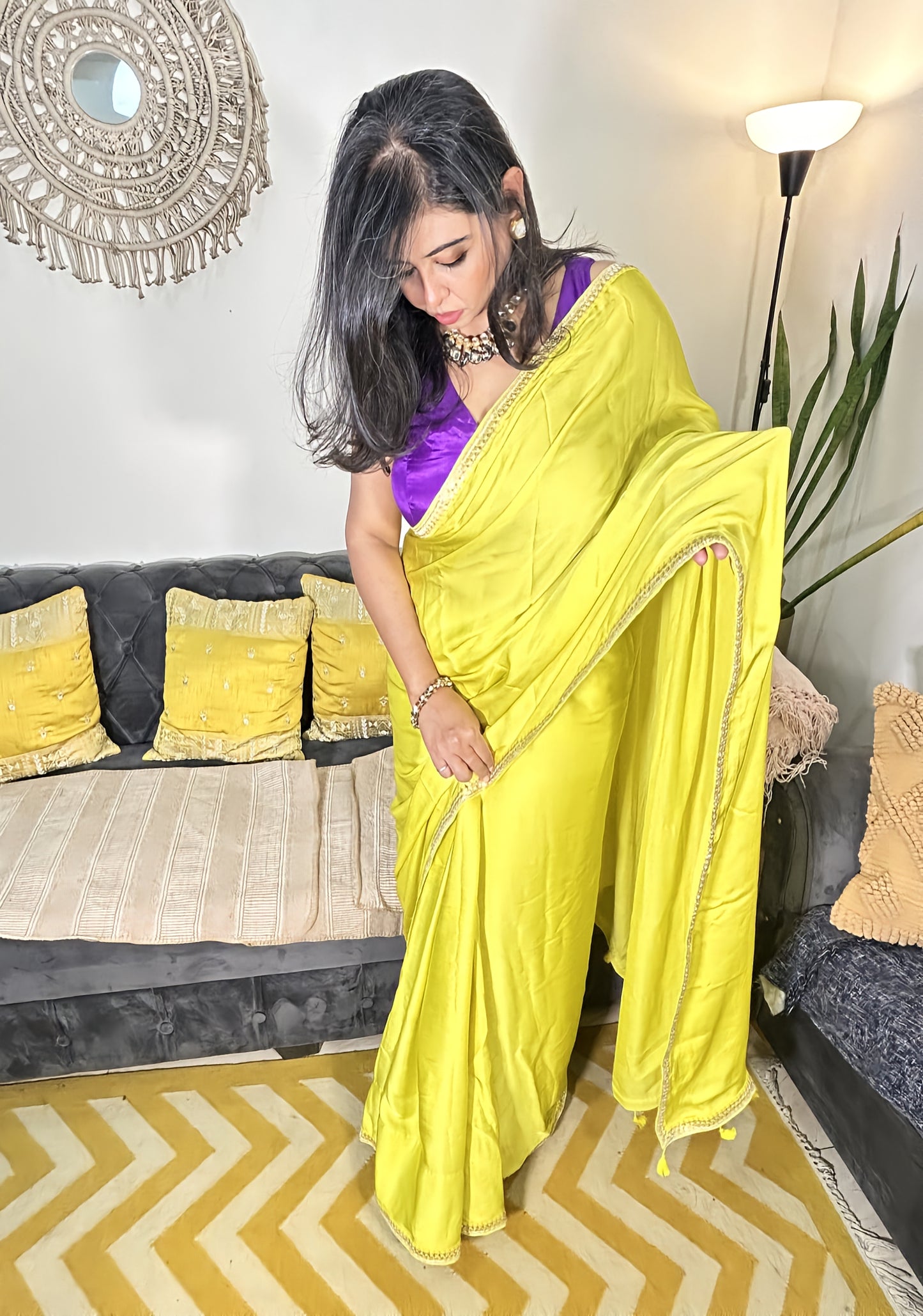Neon yellow pure modal silk saree with purple blouse and intricate designer lace border, worn with silver jewelry.