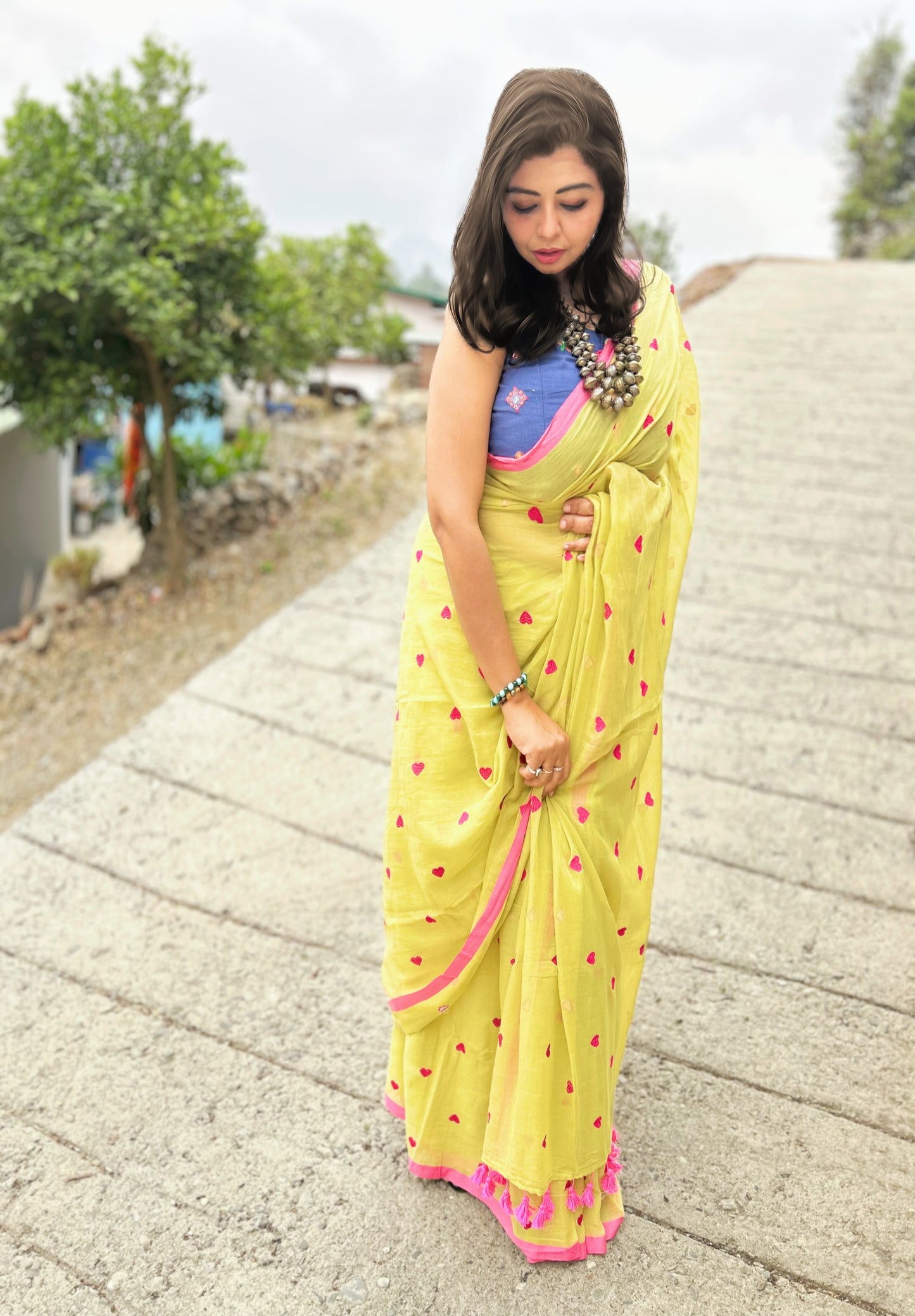 Yellow handloom Bengal cotton saree with pink border and floral motifs, worn with blue blouse.