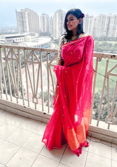 Bright pink pure handloom mul saree with gold sequin details and orange tissue crush palla worn with matching blouse.