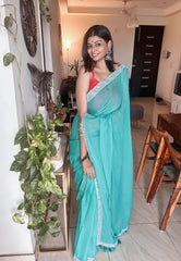 Light blue mul saree with scalloped silver border paired with a red blouse.
