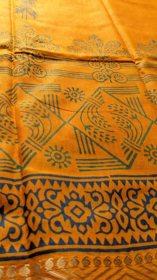 Mustard yellow cotton silk saree with intricate dark blue geometric and floral motifs and border designs.