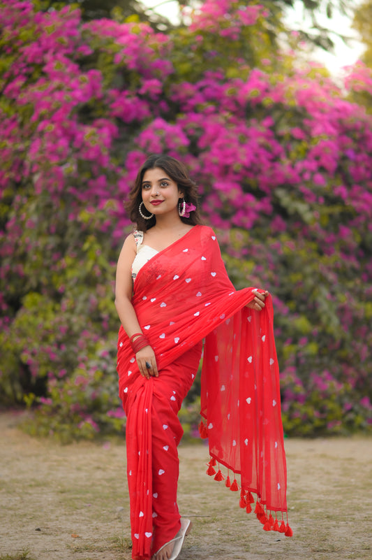 Scarlet Bengal cotton saree with white polka dots and tassel border worn by woman outdoors.