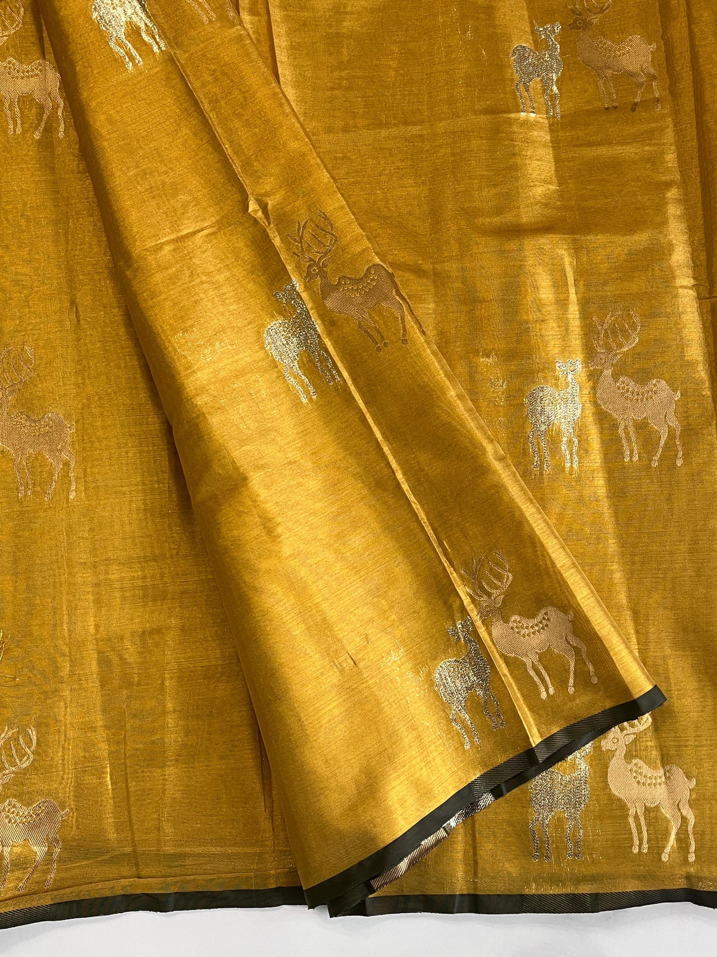 Yellow Banarasi tissue saree with silver animal motifs and black border detailing.