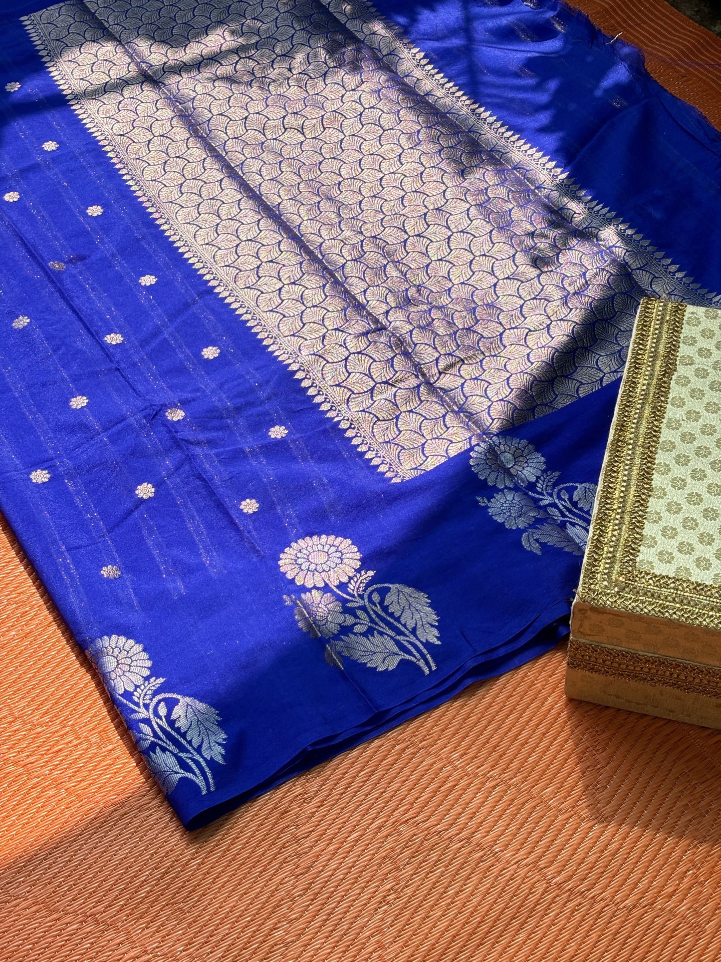 Royal blue Banarasi Katan silk saree with silver floral motifs and intricate zari border.