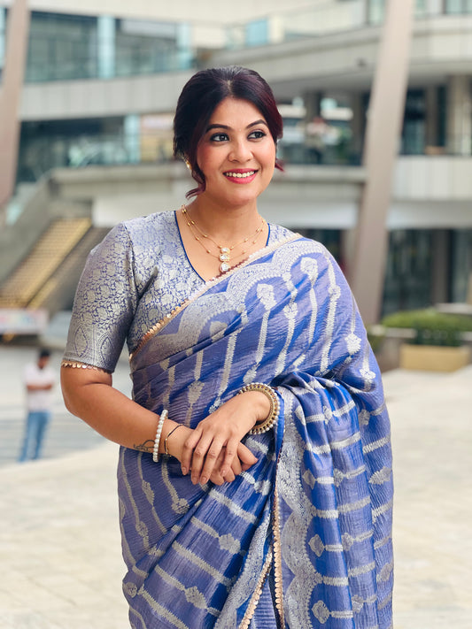 Blue crushed tissue saree with silver zigzag pattern, paired with silver sequin blouse and gold jewelry.