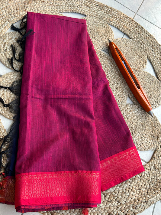 Radiant magenta cotton silk saree with vibrant red border and subtle texture on fabric.