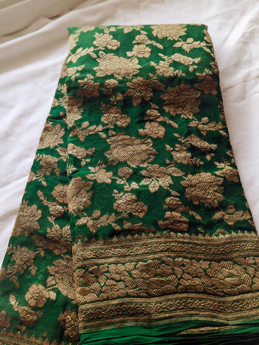 Green Banarasi Khaddi Georgette saree with intricate gold floral motifs and detailed gold border design.