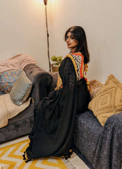 Black Mul saree with intricate orange and gold embroidered blouse, styled with loose hair and minimal makeup.