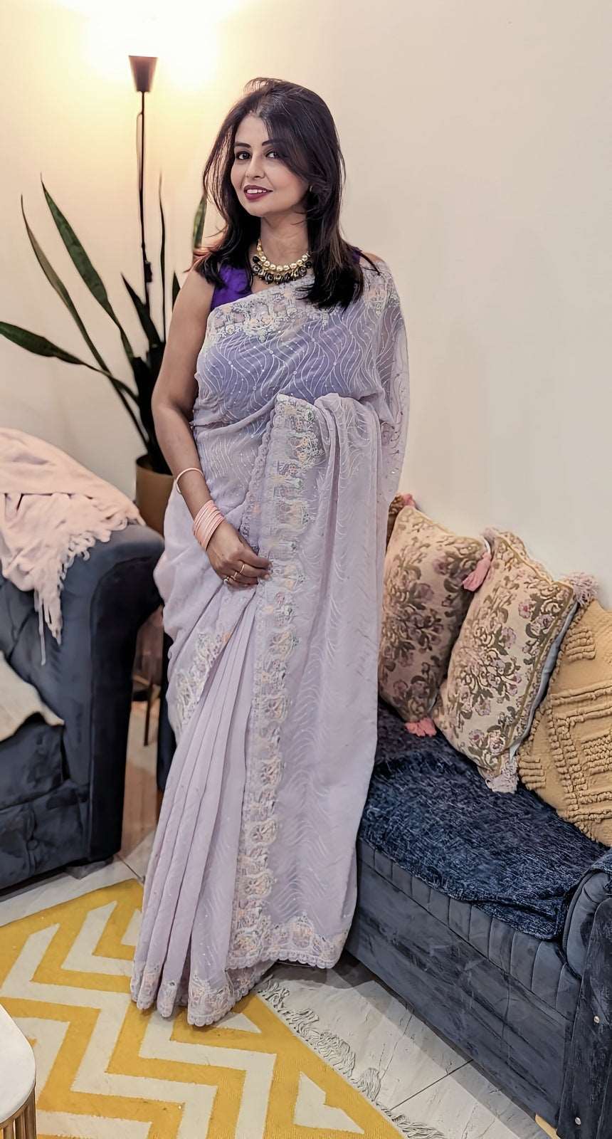 Mauve georgette saree with subtle sequin detailing worn with matching sleeveless blouse.