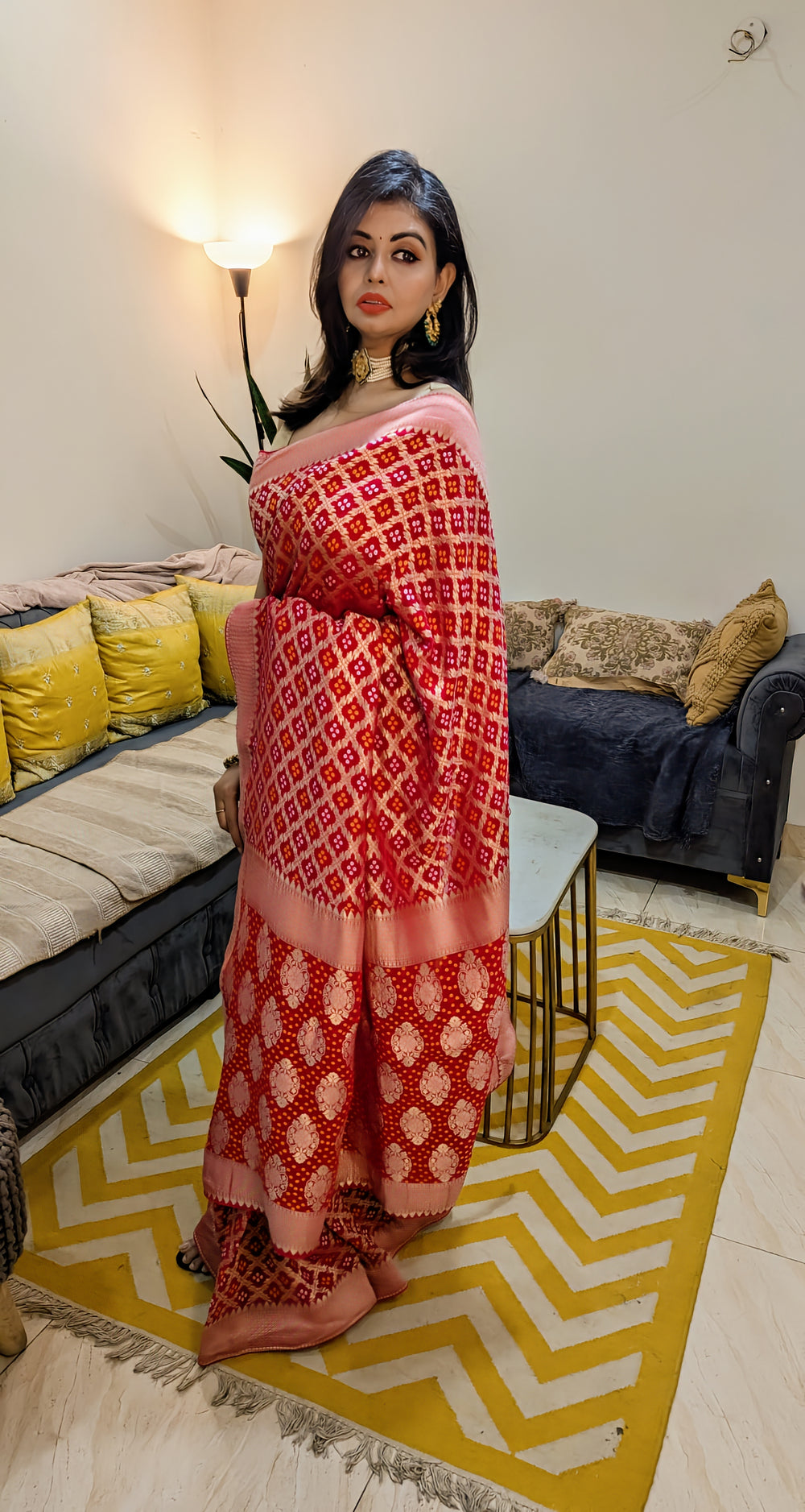 Red Banarasi Khaddi Bandhani saree with intricate golden patterns and a contrasting peach blouse.