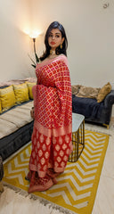 Red Banarasi Khaddi Bandhani saree with intricate golden patterns and a contrasting peach blouse.