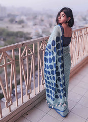 Light blue handloom saree with large dark blue polka dots and delicate border, styled with a dark blouse.