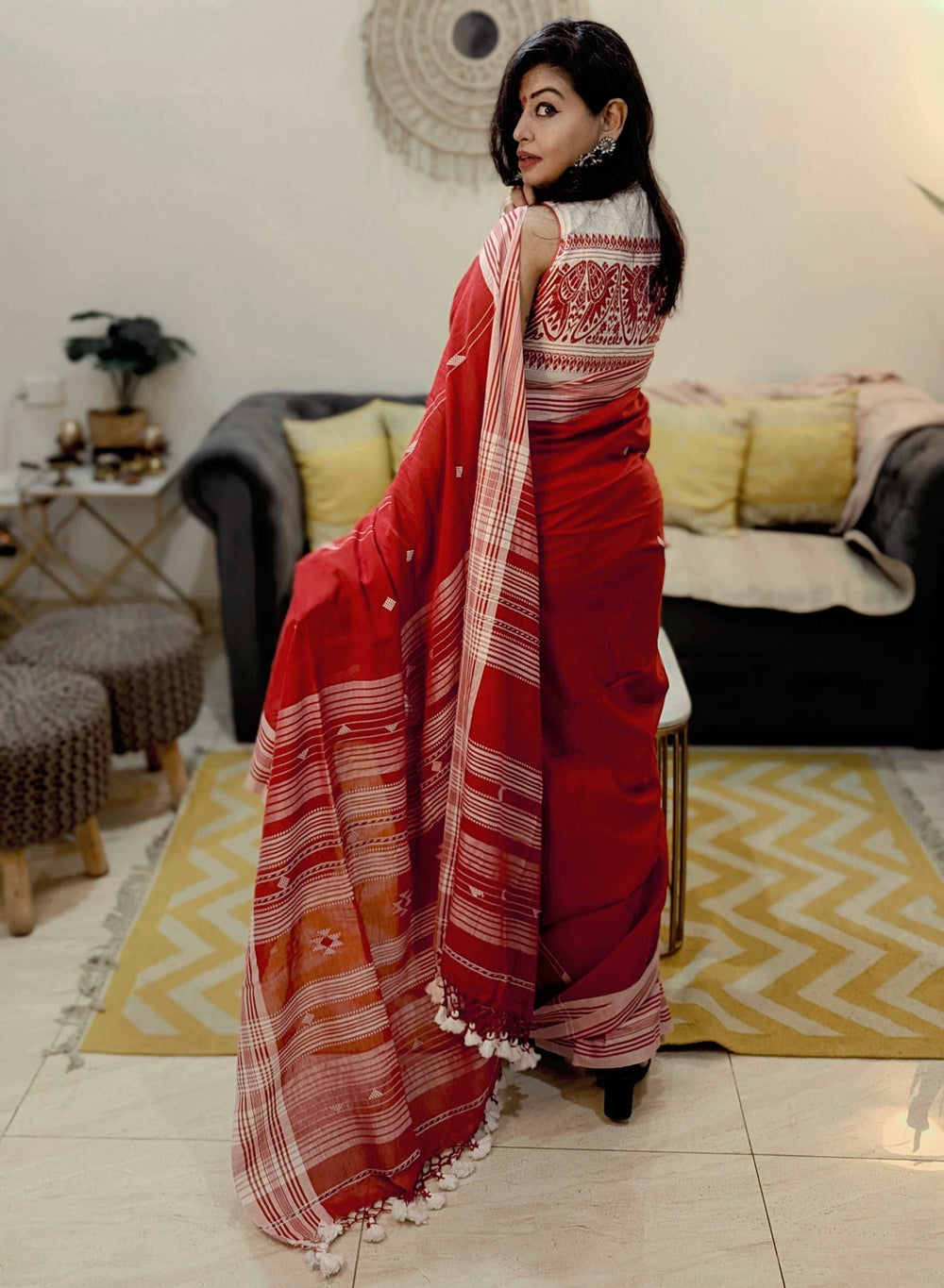 Red Bhujodi Bengal handloom saree with white geometric patterns and striped pallu, worn by a woman.