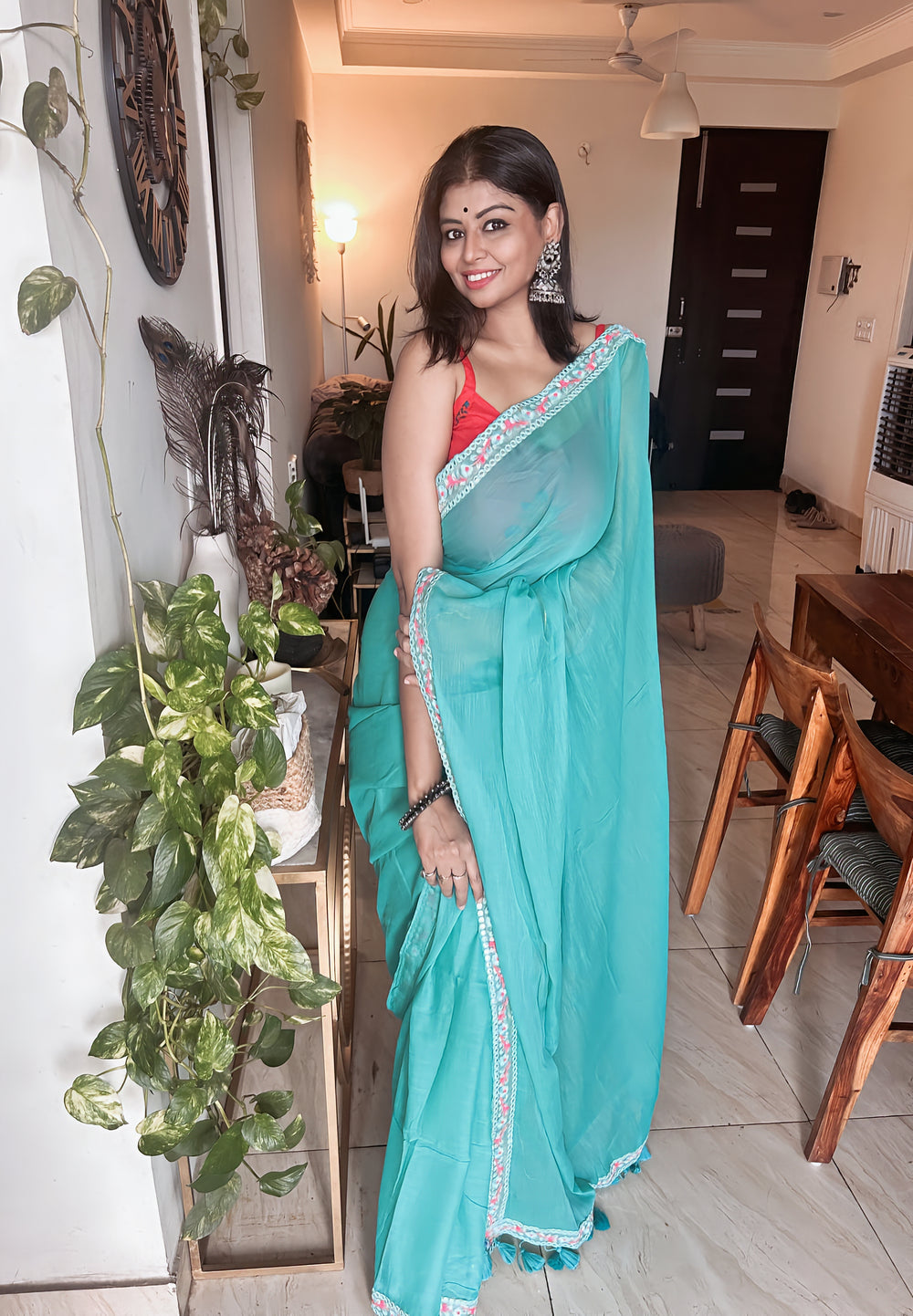 Light blue mul saree with scalloped silver border paired with a red blouse.