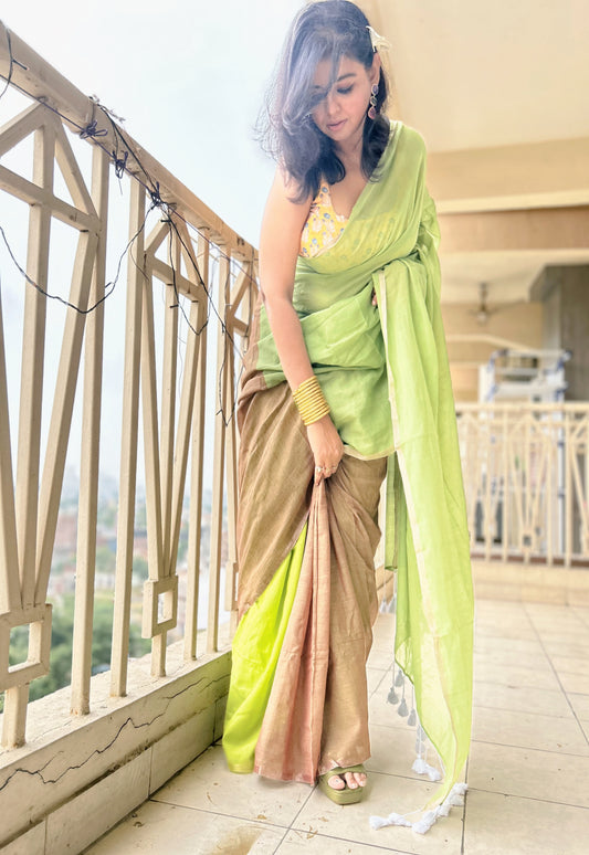 Light green and beige cotton blend saree with subtle texture, draped on a model in a bright setting.