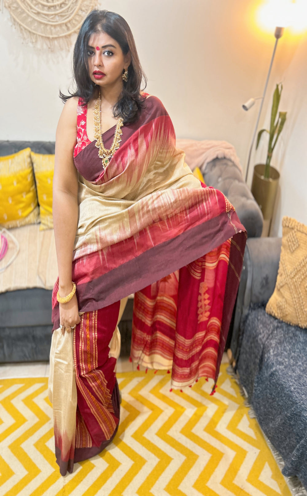 Woman wearing red and gold Bengal Loom saree with intricate border, styled for festive occasion.