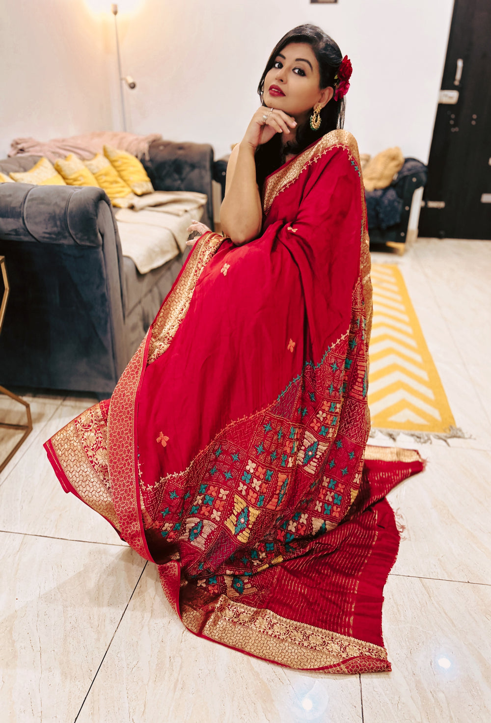 Deep blood red Pure Dola Silk Lambani saree with intricate multicolor geometric border and gold detailing.