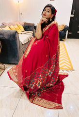 Deep blood red Pure Dola Silk Lambani saree with intricate multicolor geometric border and gold detailing.