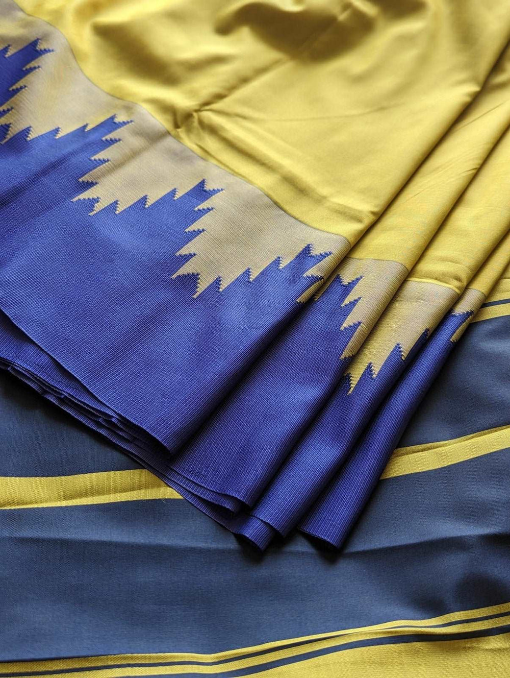 Lime green silk saree with navy blue zigzag border and gold accents.