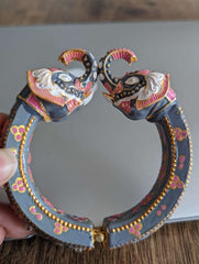 Grey bangles with intricate pink and gold Kundan-style elephant head designs on each end.